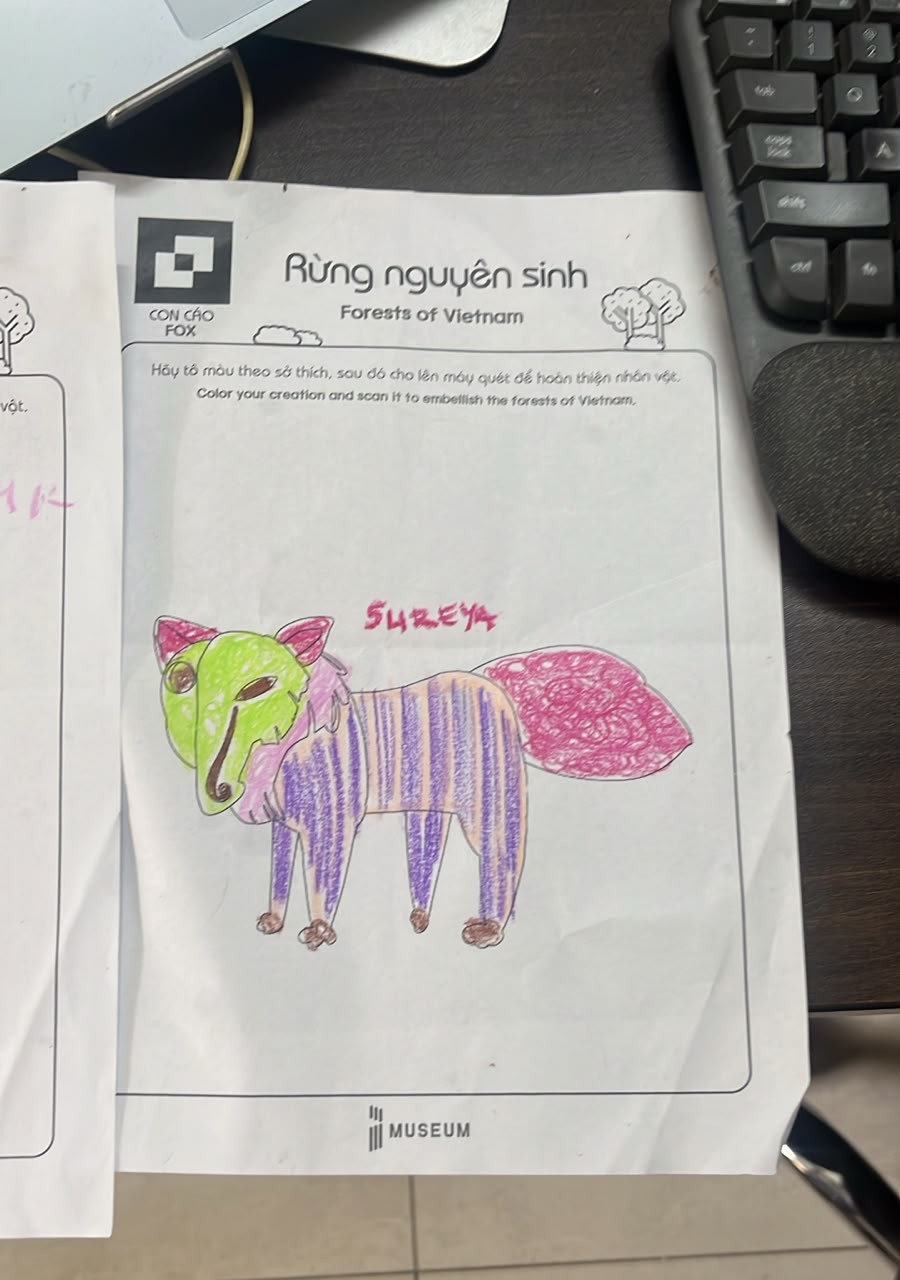 A museum coloring sheet of a fox colored with a green face, purple striped body and pink swirled tail, with SUREYA handwritten in pink